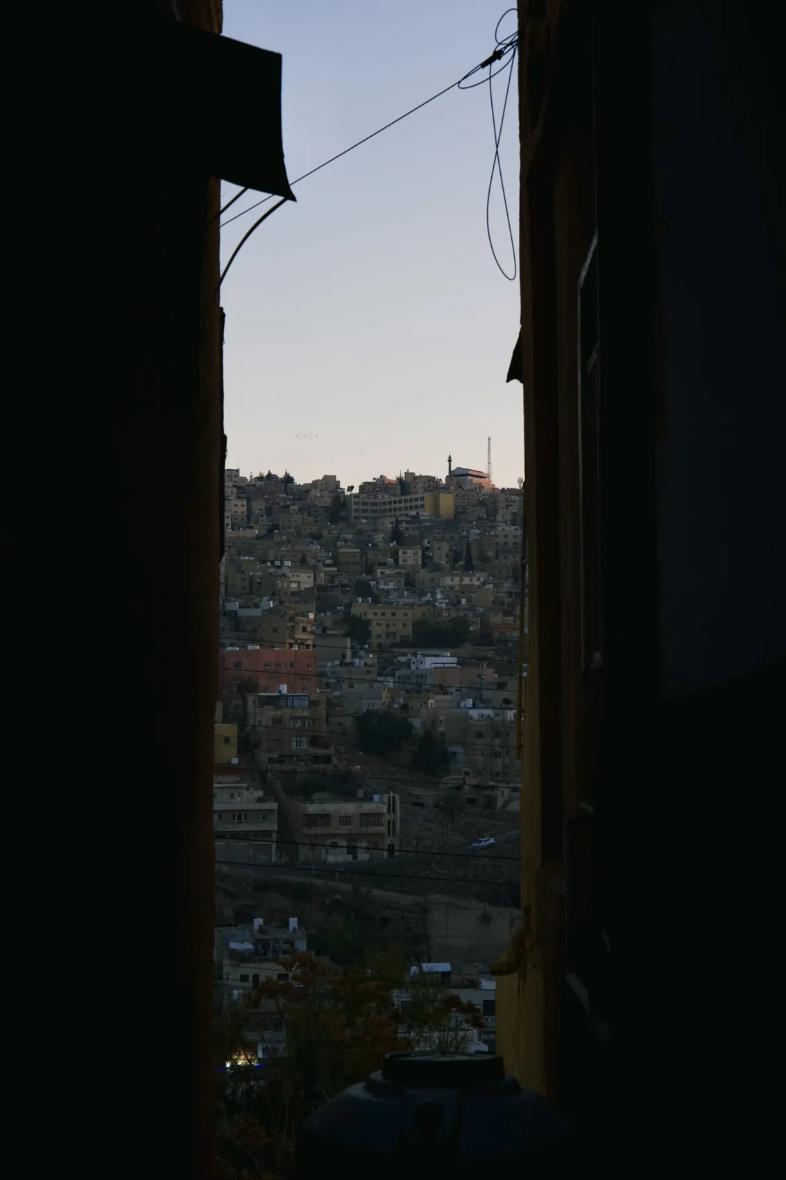 A thin slice of Amman seen through a dark doorway.