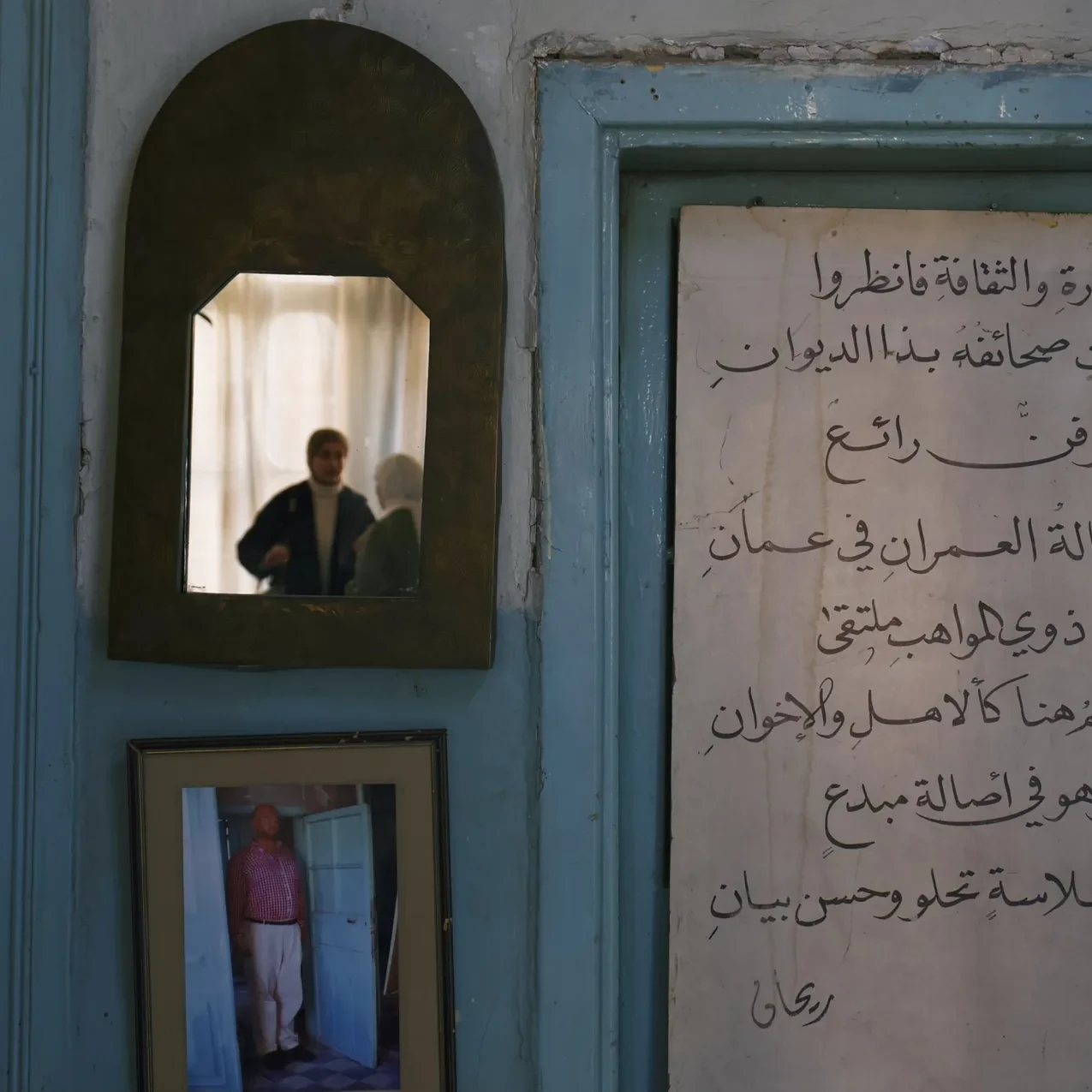 Arabic text and a small mirror in an Amman room.