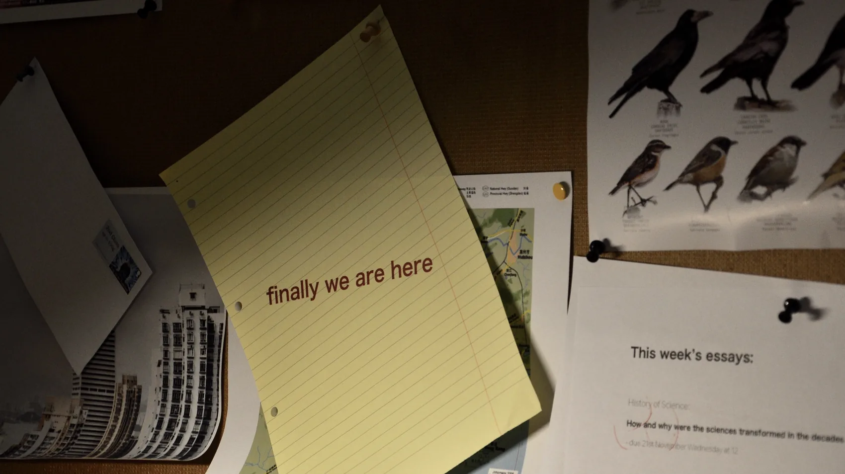 A yellow notebook titled finally we are here on a desk.