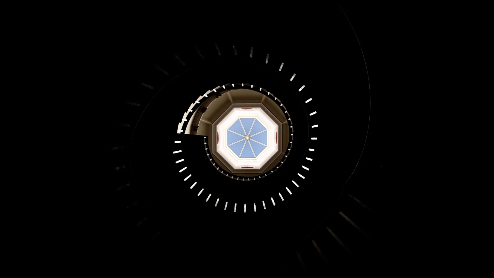 A circular ceiling opening seen from below in darkness.
