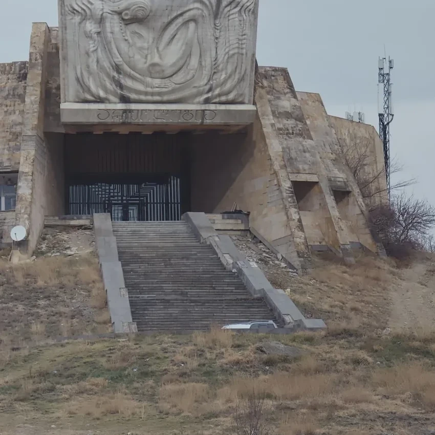 A person approaching a hilltop monument in Georgia.