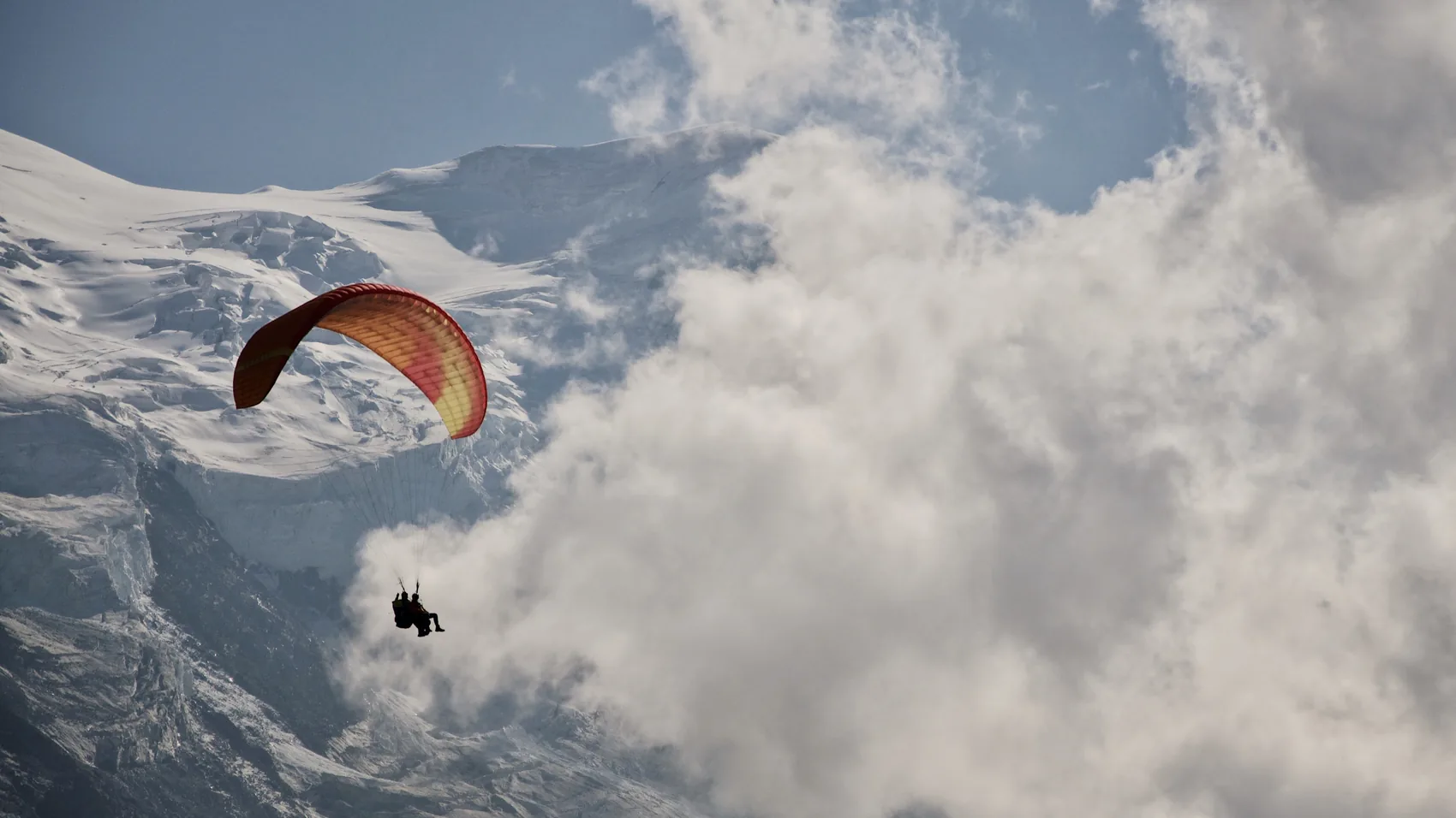 A paraglider suspended above Chamonix cloud.