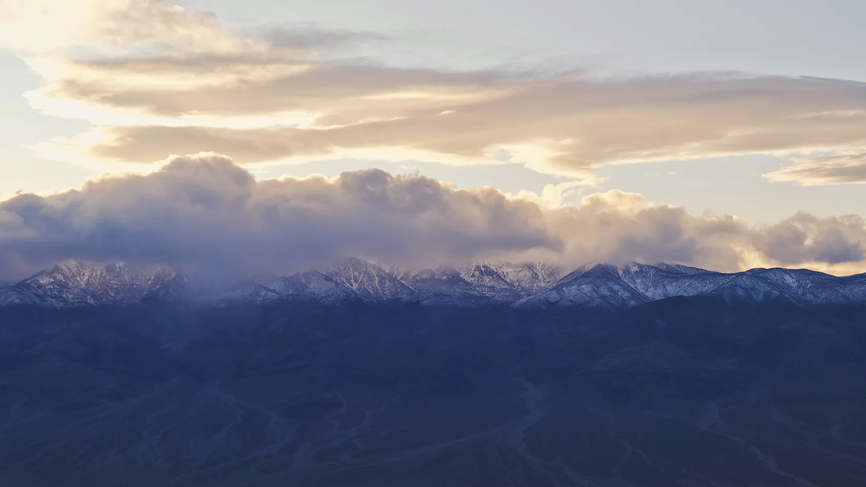 Snow-touched mountains beyond Death Valley at sunset.