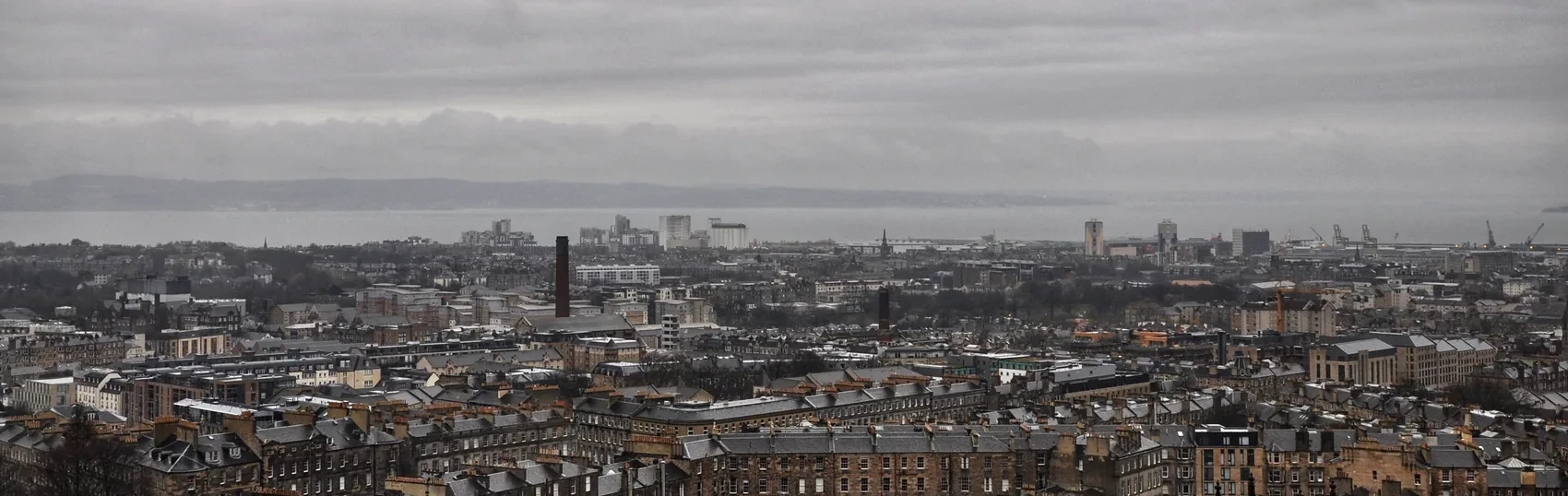 A broad grey Glasgow skyline from above.