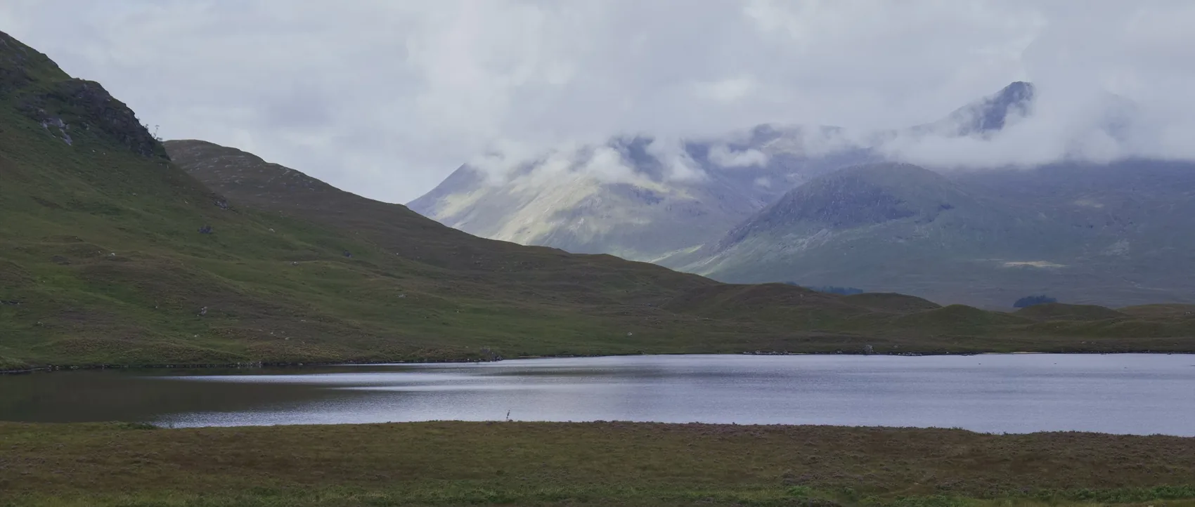 A grey loch beneath low cloud in the Highlands.