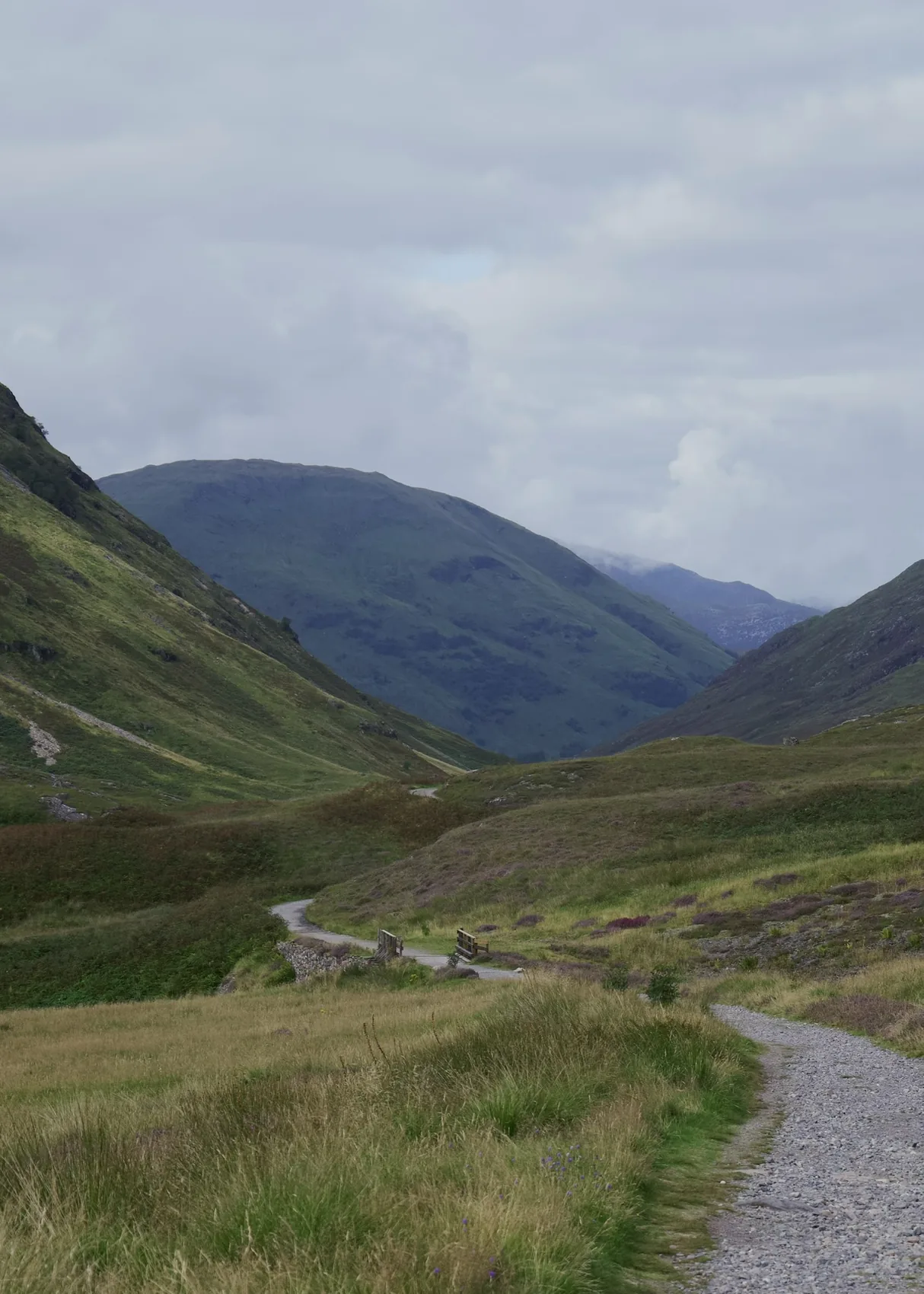 A winding path leading into a green Highland valley.