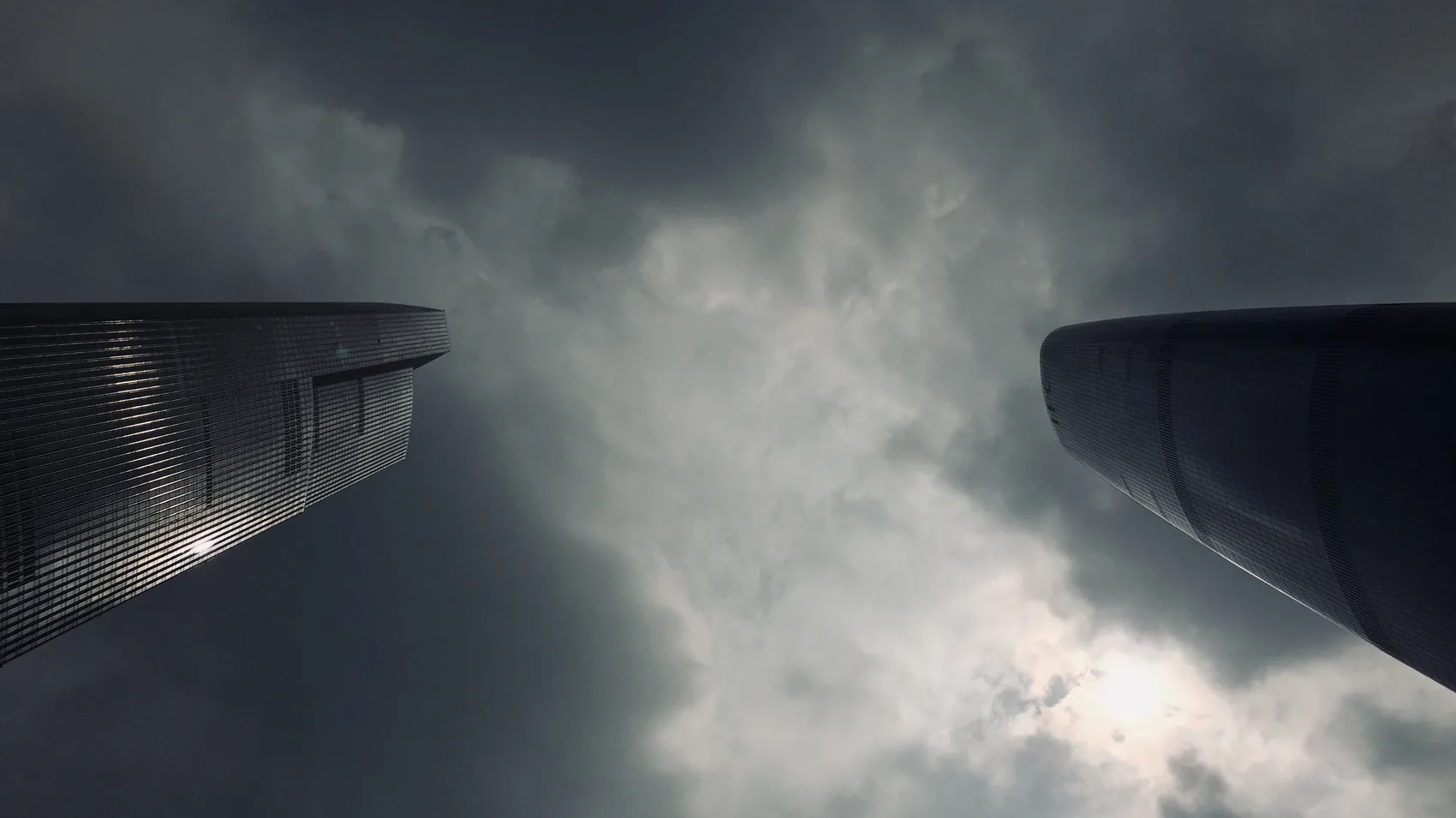 Two towers seen against a dark storm sky in Guangzhou.