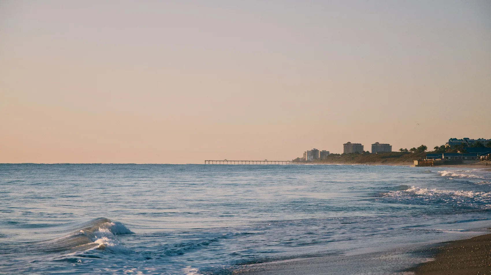 A soft Jupiter shoreline in pale evening light.