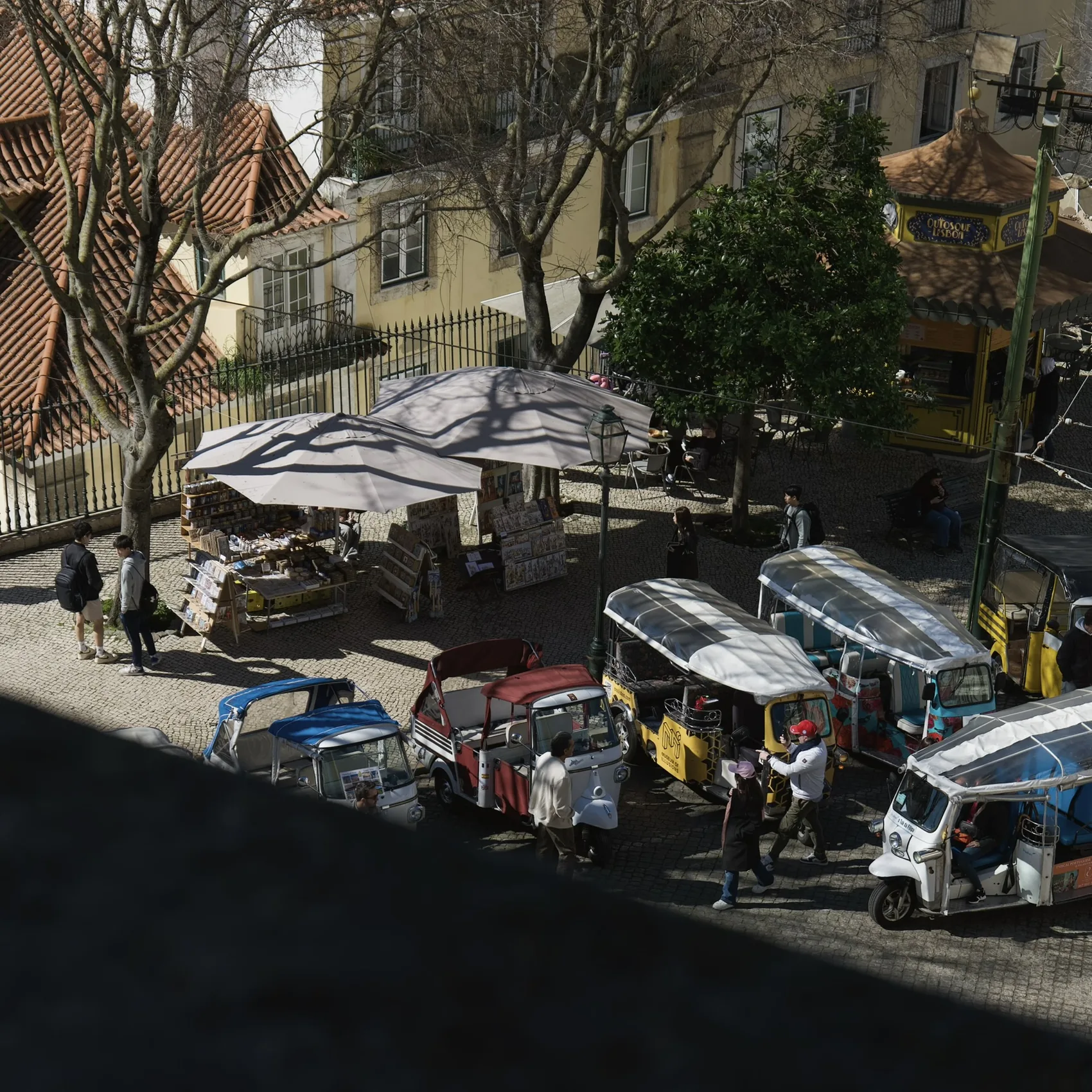 Lisbon tuk-tuks and umbrellas seen from above.