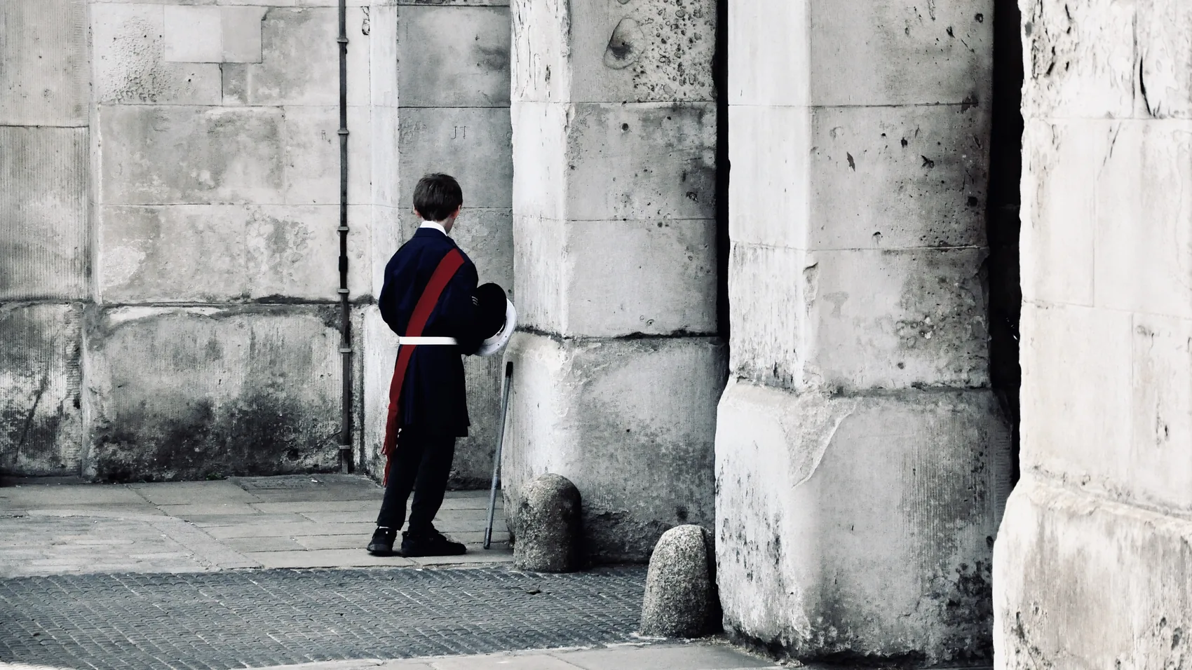 A guard standing against pale London stone.