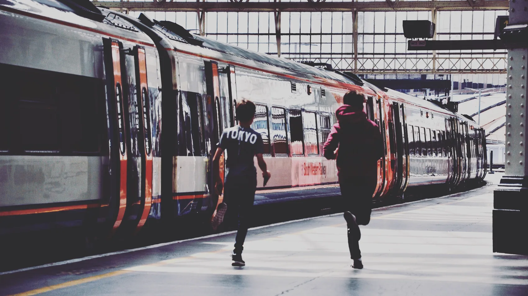 A person crossing a bright London train platform.
