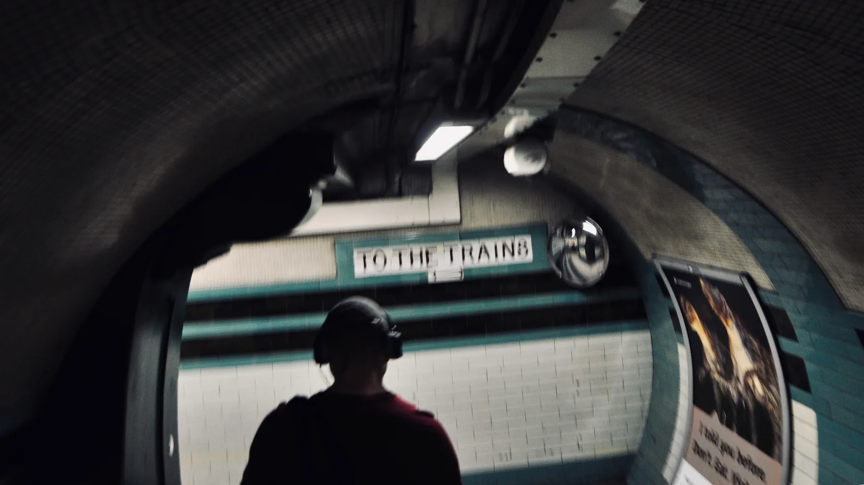 A silhouetted figure beside a London Underground train.