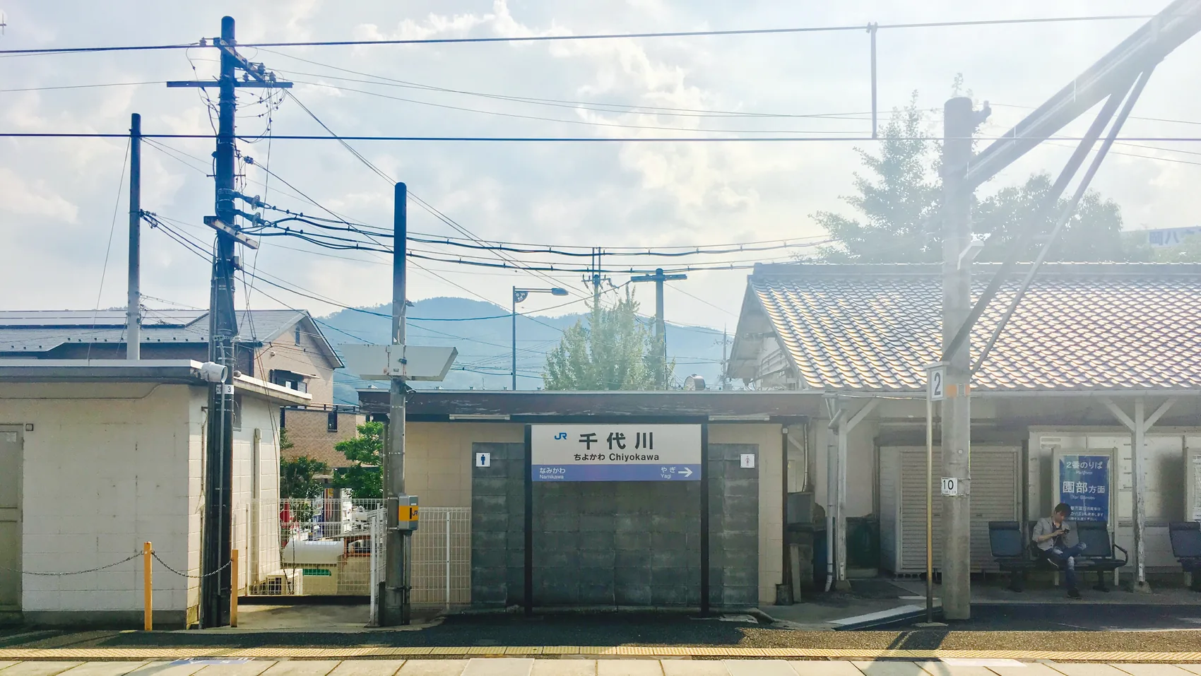 A bright Osaka station frontage in summer light.
