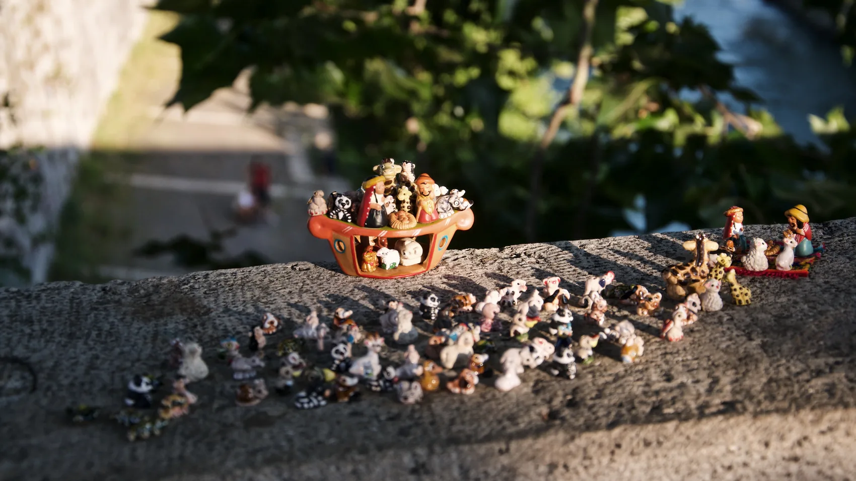 Small toy figures lined along a stone edge in Rome.