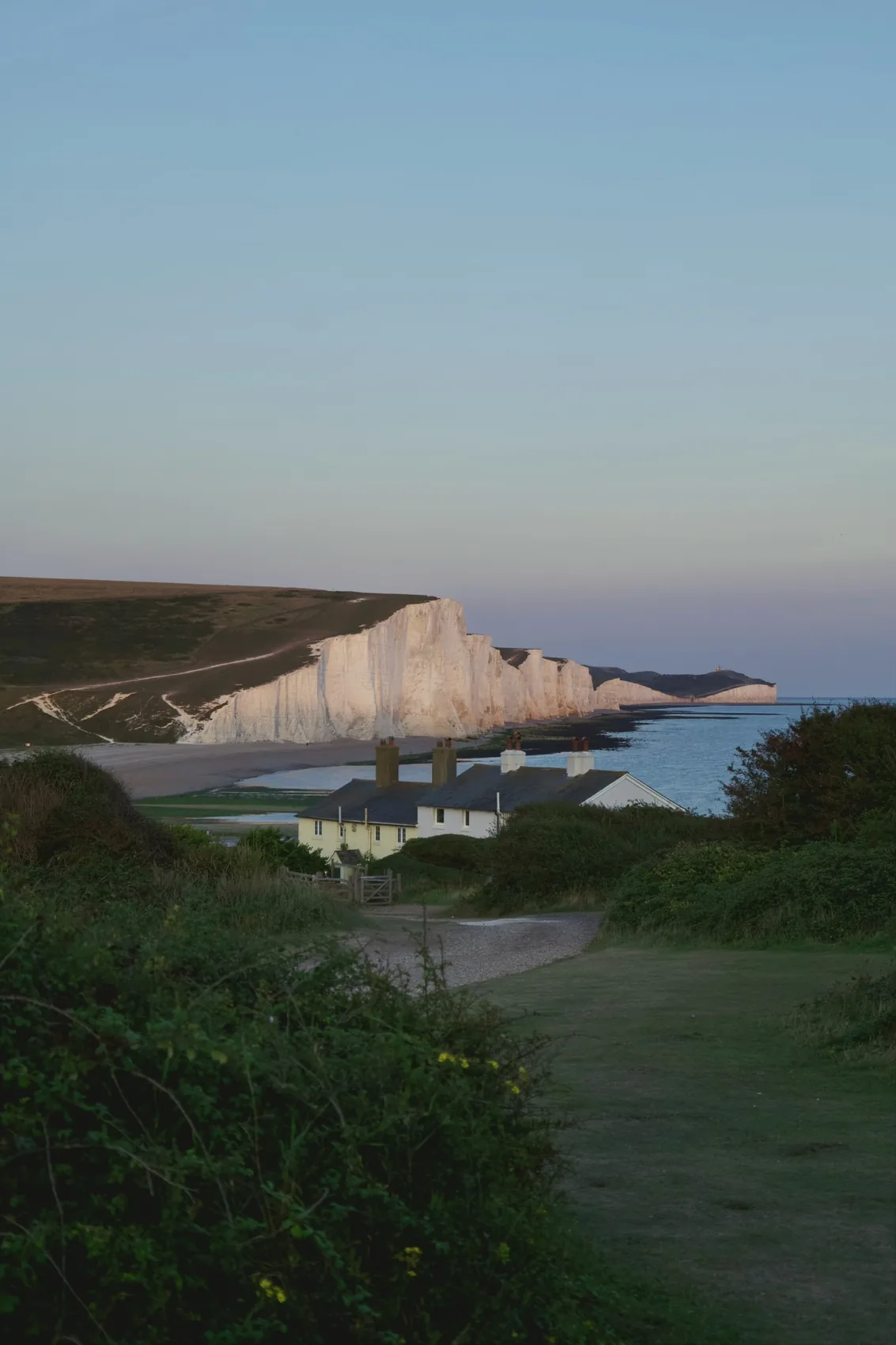 White chalk cliffs at Seaford in low warm light.