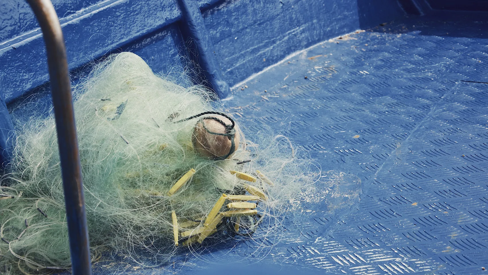 Fishing net and rope on a blue Shanwei boat deck.