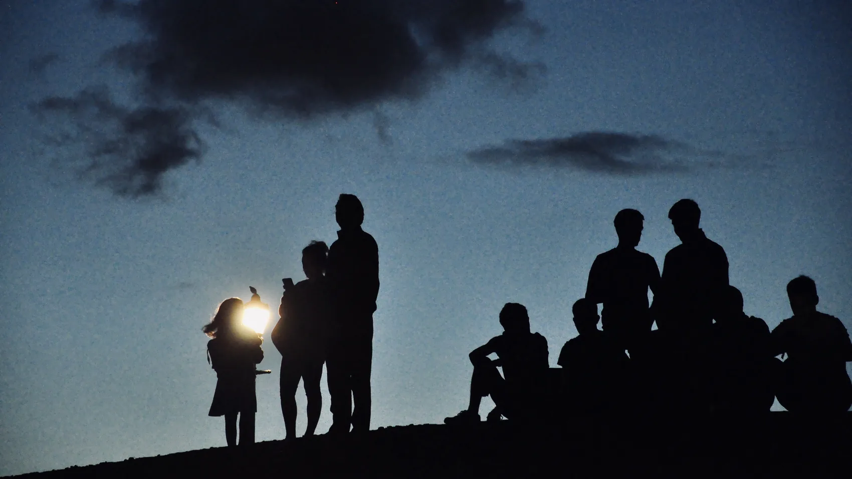 People in silhouette along a low southern England horizon.