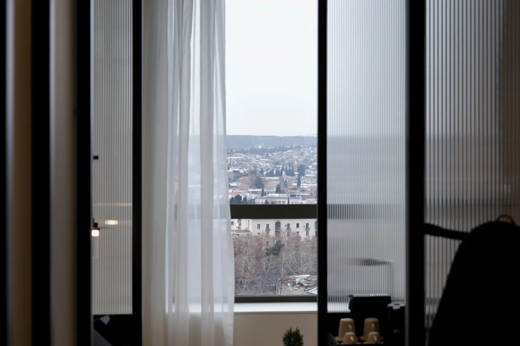 Tbilisi seen through hotel curtains.