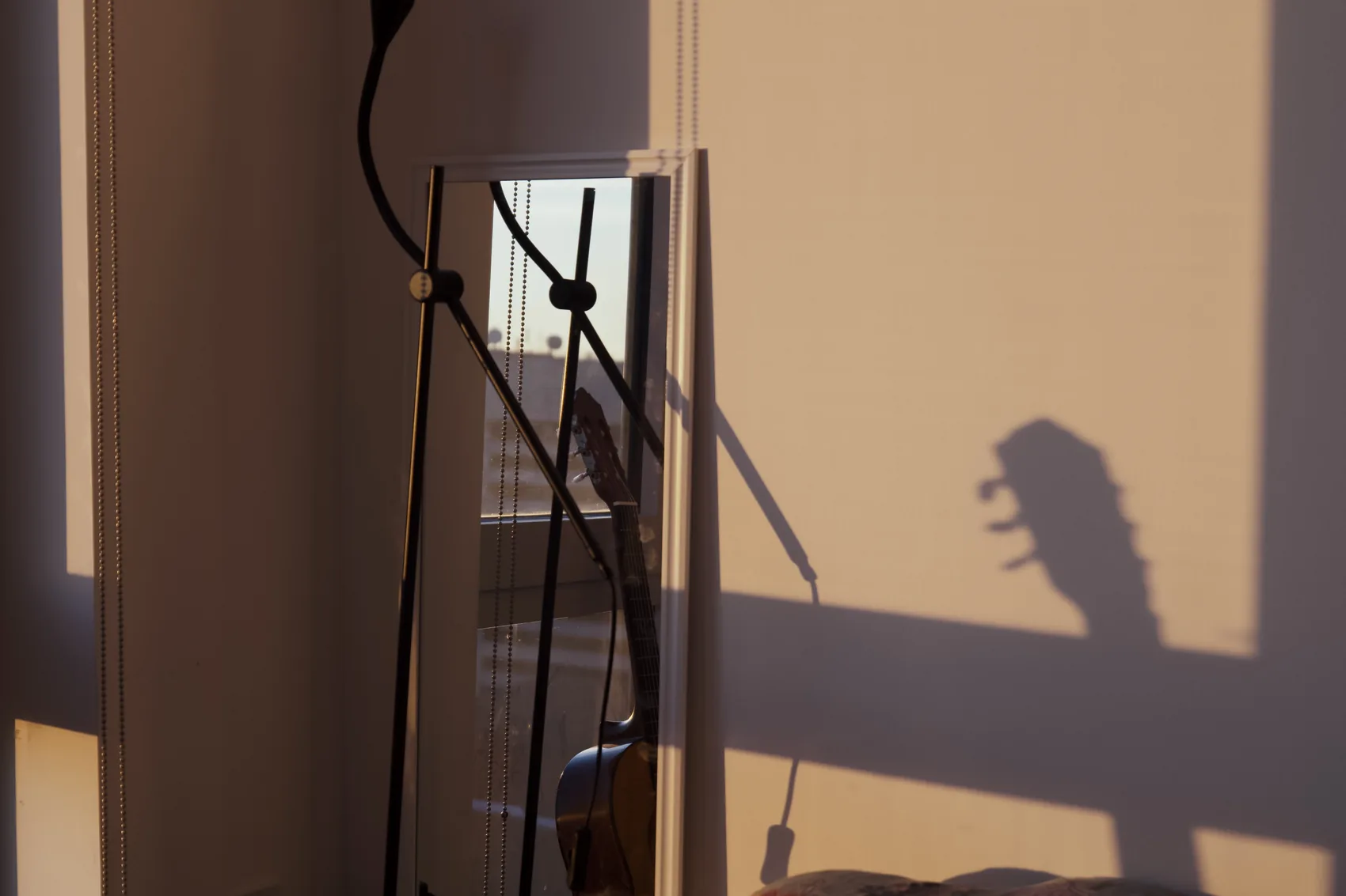 A guitar-shaped shadow falling across a room wall.