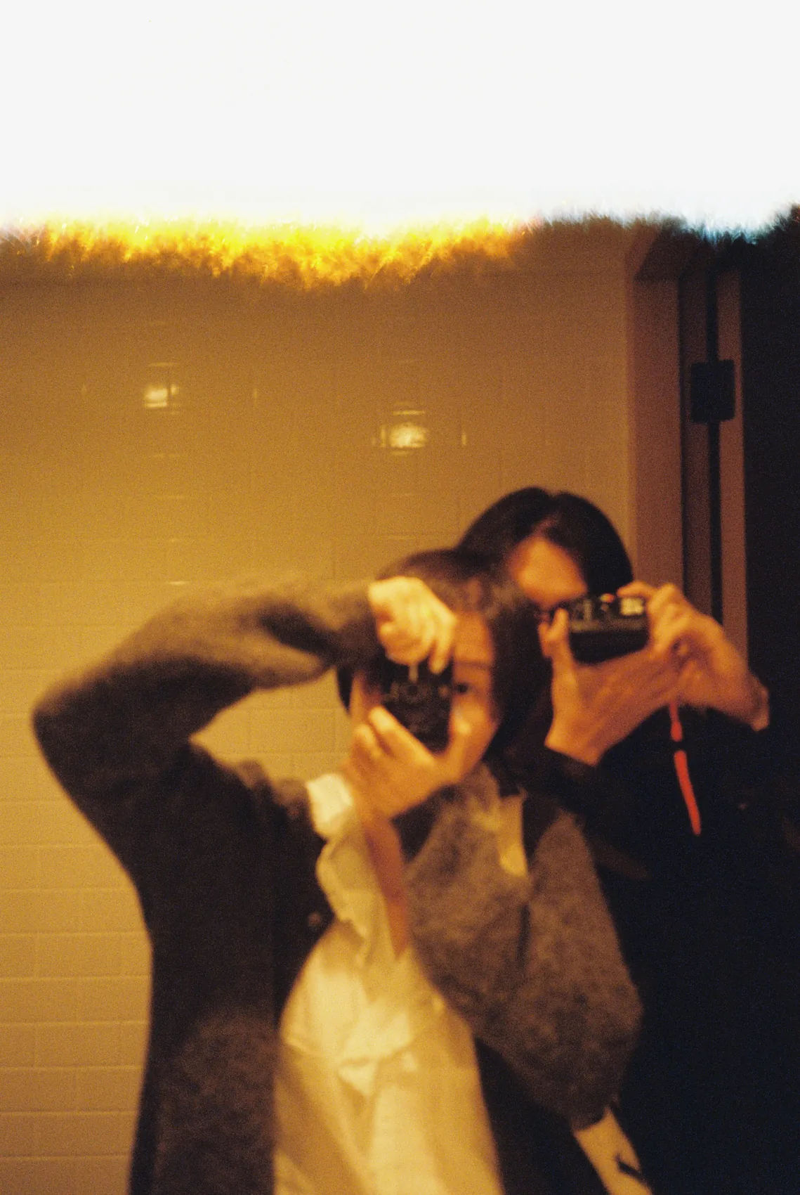 Two people dancing in blurred warm party light.