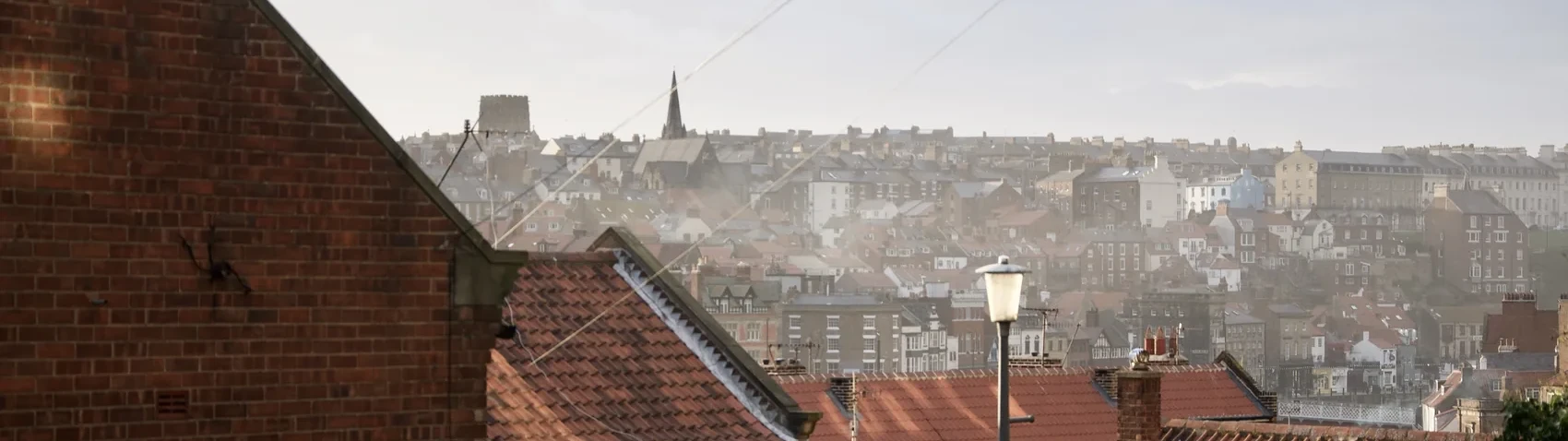 Whitby rooftops receding into mist and low light.