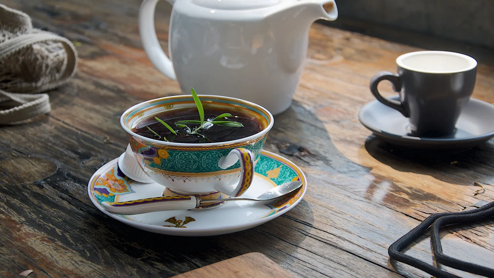 A tea cup and coffee cup on a wooden Xiamen table.