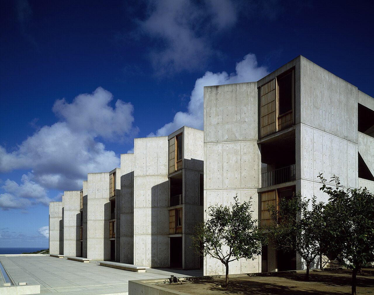 The Salk Institute for Biological Studies, La Jolla, California — the iconic Louis Kahn courtyard with the Pacific Ocean visible between the symmetrical concrete laboratory buildings.