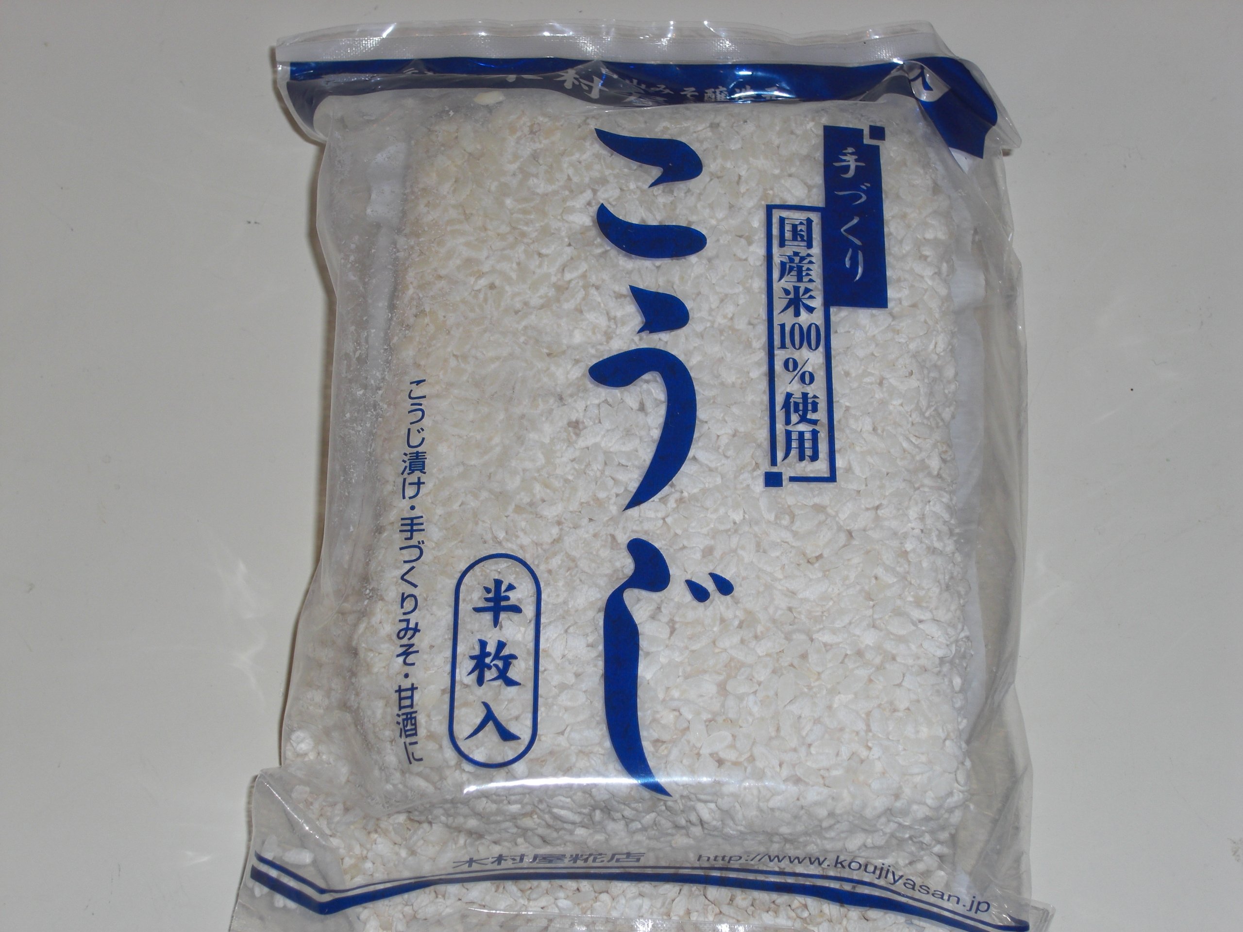 Loose grains of rice koji covered in white Aspergillus oryzae mould, used in the fermentation of soy sauce, sake, and miso